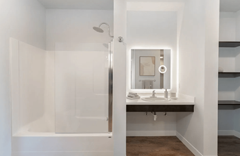 A bathroom with a sink and a shower and a mirror